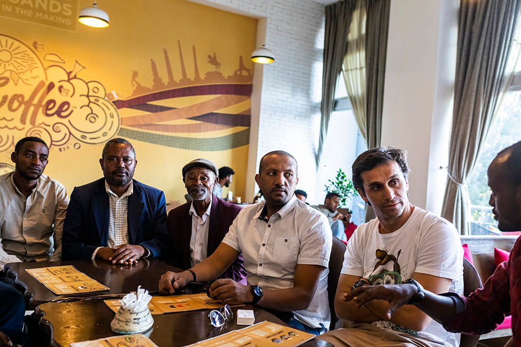 Ethiopian producers and Coffee Island stuff sitting in a coffee place in Ethiopia
