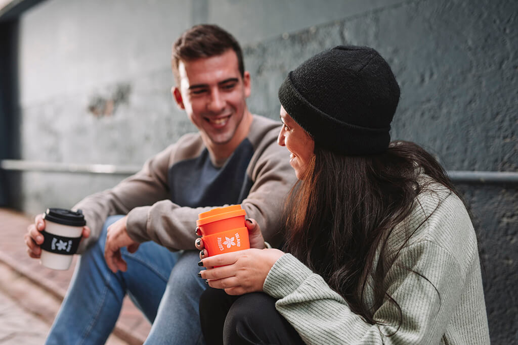 A man and a woman discussing while enjoying their tea from Coffee Island.