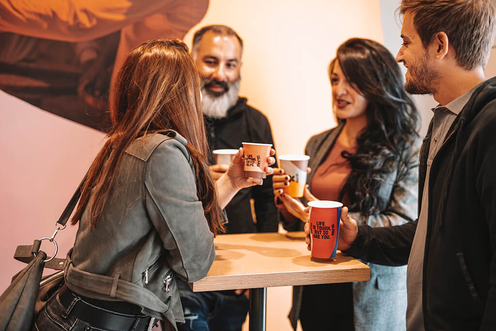 A group of friends gathered in a coffee island shop drinking coffee.