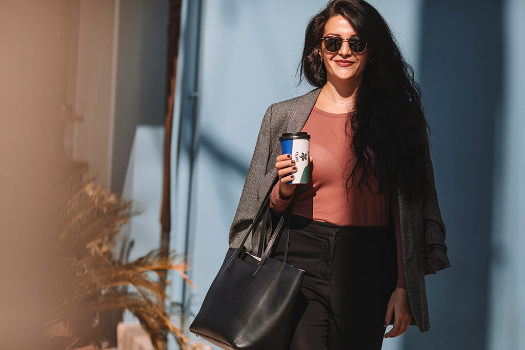 A woman holding her coffee island cup.